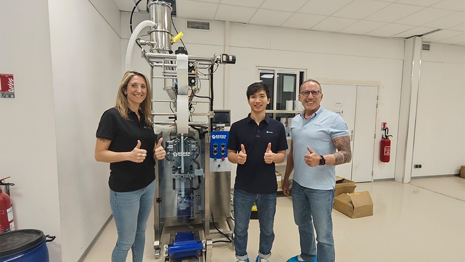 Henry and clients in front of stick sachet packing machine
